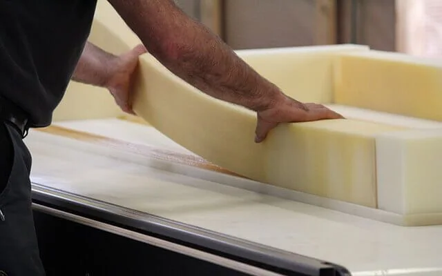Manual positioning of a foam mattress core during production, where the Duero head is used